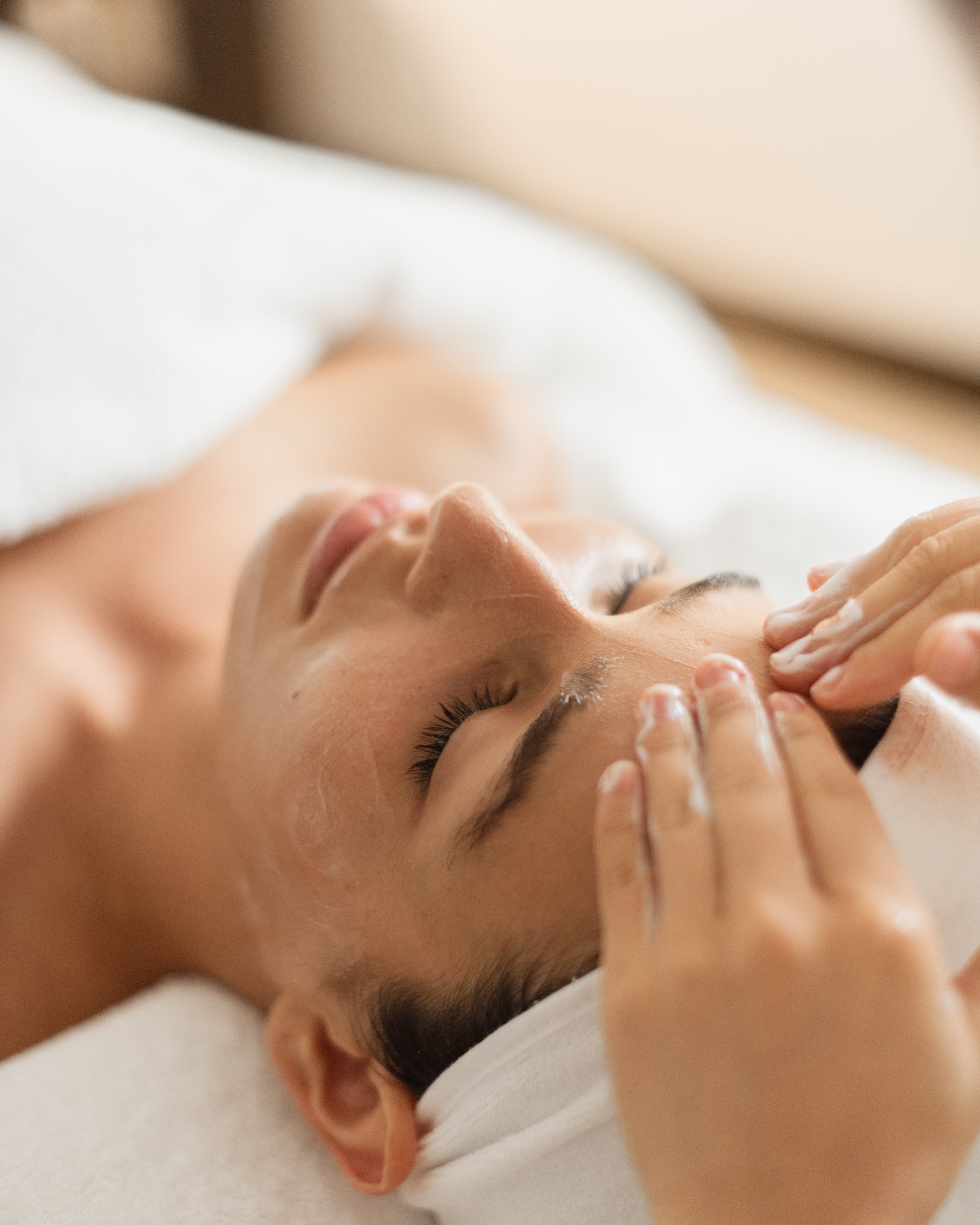 Person receiving a facial massage in a spa setting
